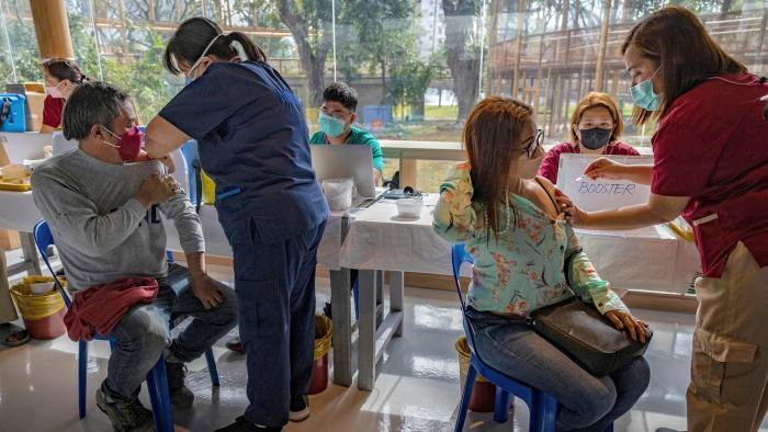 People receive a dose of the Pfizer Covid vaccine in Manila, Philippines