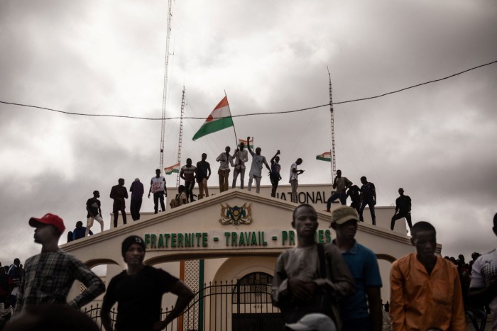 Protesters hold a Niger flag during a demonstration on independence day in Niamey on August 3, 2023