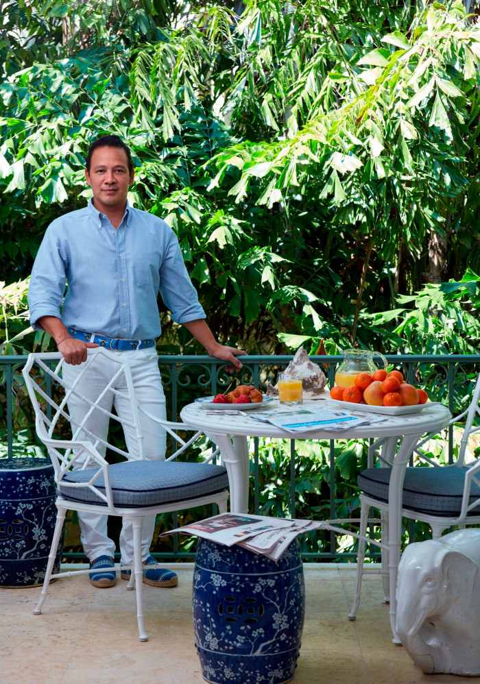 man stands beside a table laden with fruit in a garden