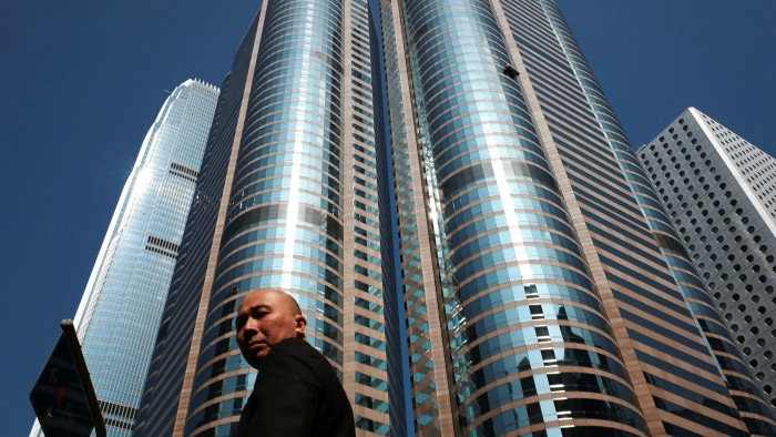 A man walks past the Hong Kong Exchange Square building in Central of Hong Kong