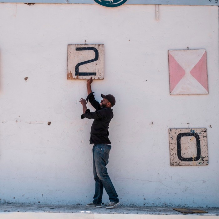 A man changes the scoreboard to 2-0 during a game