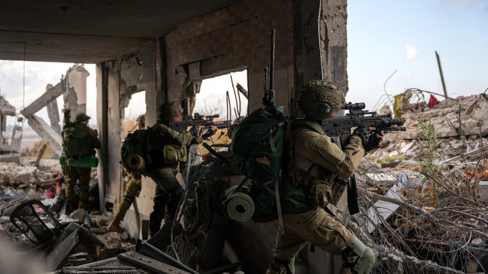 Israeli soldiers firing from their positions inside a bombed out building