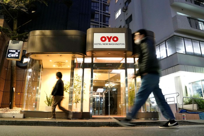 Pedestrians walk past an Oyo hotel in Tokyo, Japan. Oyo, an Indian multinational, wants to raise $1.1bn through a listing