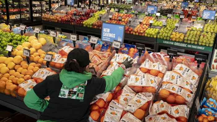 Worker stocks items in a grocery store.