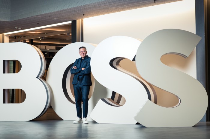 Christopher Koerber standing in front of big letters that spell B O S S 