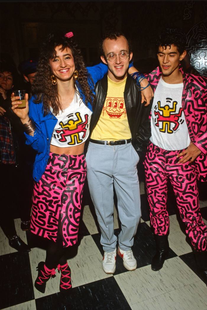Haring at the opening of his winter 1983 show in New York, with models wearing clothes emblazoned with his work
