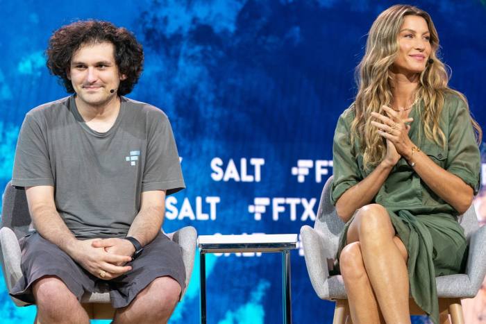 Sam Bankman-Fried wearing shorts and T-shirt sits next to Gisele Bündchen on a conference stage 