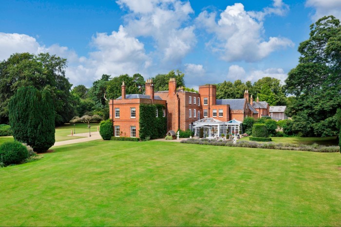 A vast red brick country house on expansive landscaped grounds