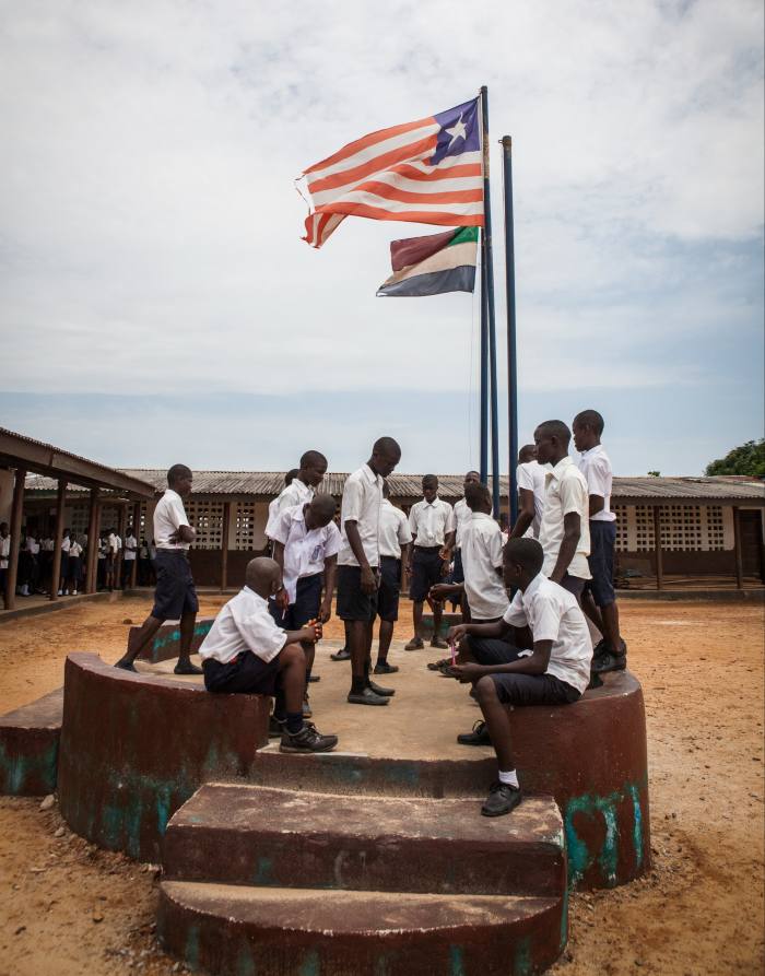 Students standing around a flag pole during break time