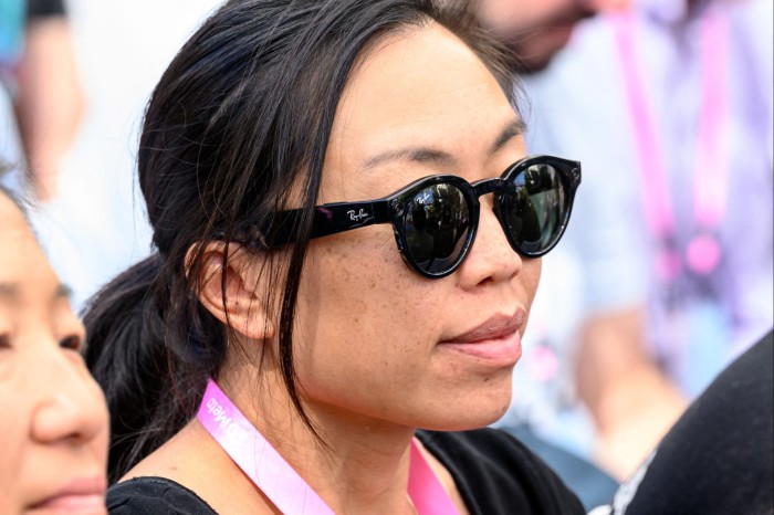 A woman wears a pair of Ray-Ban Meta smart glasses