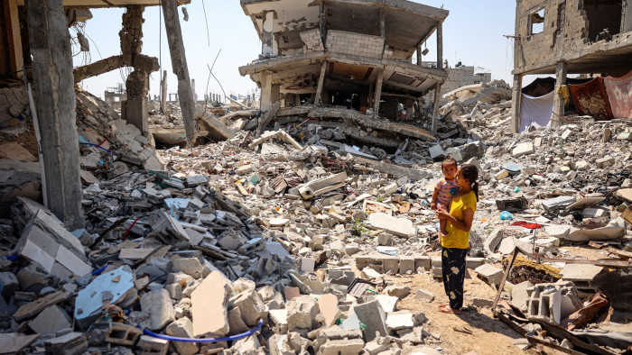 A woman and child amid the rubble of buildings in Khan Yunis in the southern Gaza Strip 
