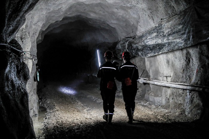 Miners walking inside a mineshaft