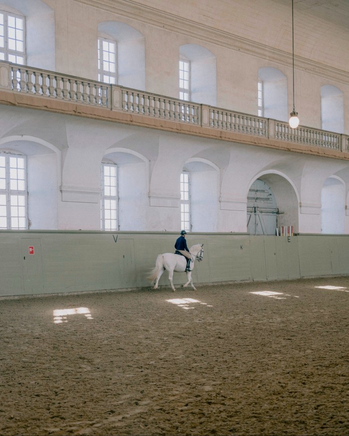 A man riding a horse in the royal stables at Christiansborg Palace