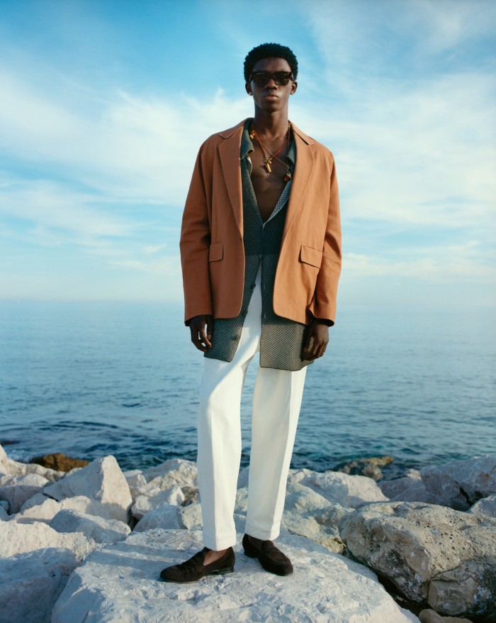 Zegna vicuña cotton jacket, £2,569, and wool trousers, £950. Isa Boulder rayon polo shirt, €410. Brioni leather loafers, £870. Etnia Barcelona acetate Bertini sunglasses, £309. Versace golden-metal La Medusa earrings and golden-metal necklace, both POA