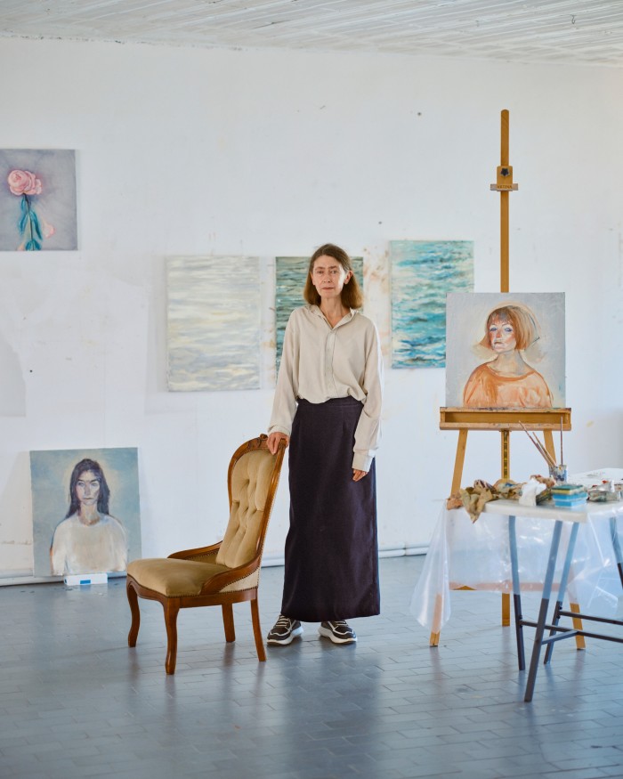 Paul in her studio on the Zattere, with (on easel) Chiara, 2023, and (top far left) Peony Shedding its Petals, 2023
