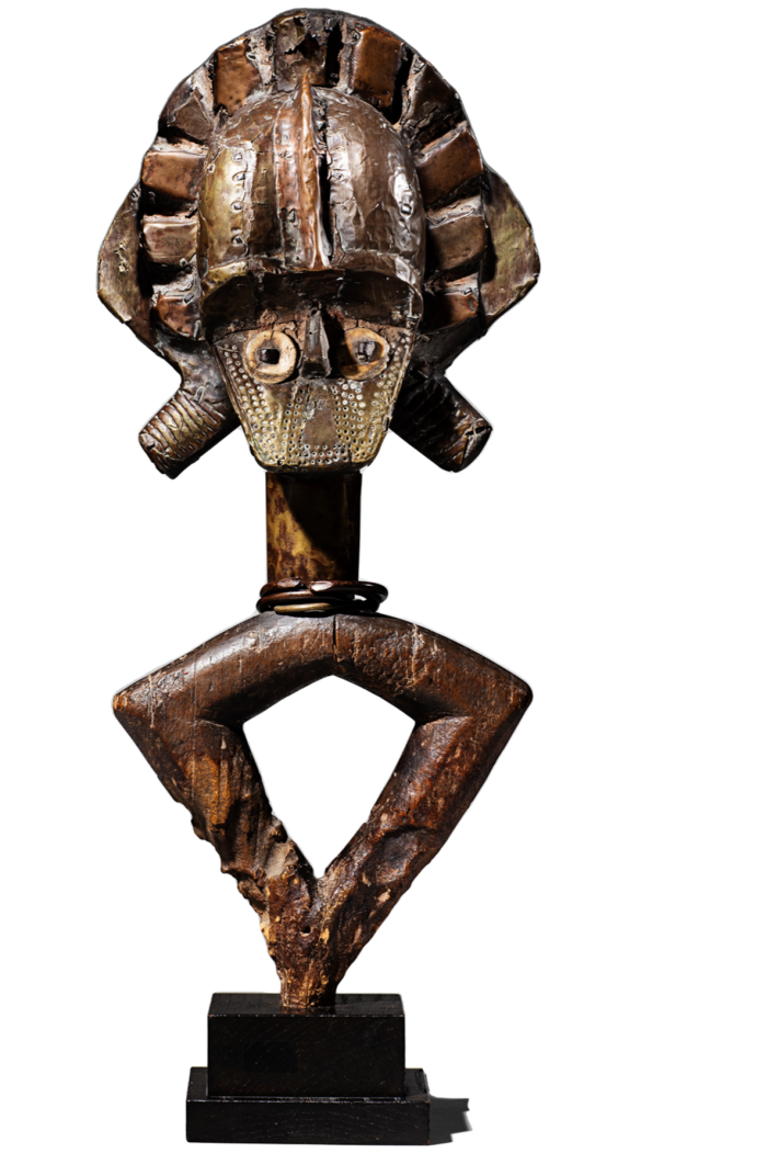 A carved wooden head with a schematic body - slight trunk and legs extended and joined at the feet