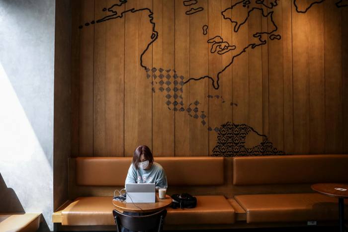 A woman sits in the inside area of a South Korean cafe