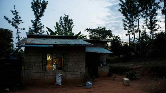Light to study by: a school student admires a solar-powered bulb at his home in Kenya