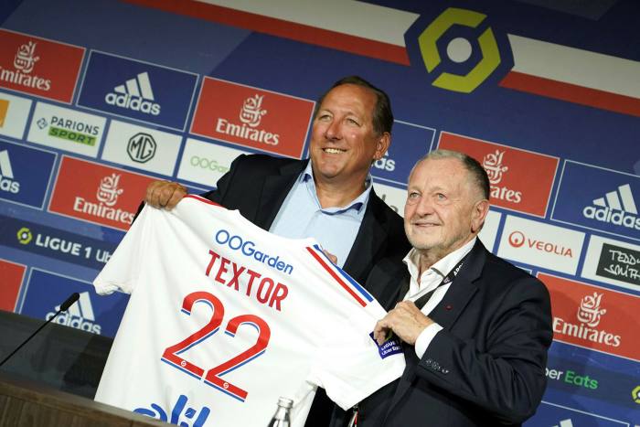 Lyon’s soccer club president Jean-Michel Aulas, right, and John Textor, a US digital entrepreneur, left, pose with the Lyon’s team jersey