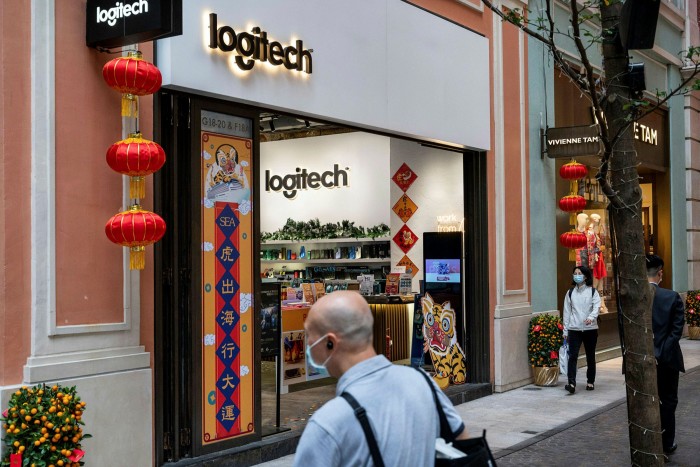 Pedestrians walk past the Swiss electronics company Logitech store in Hong Kong