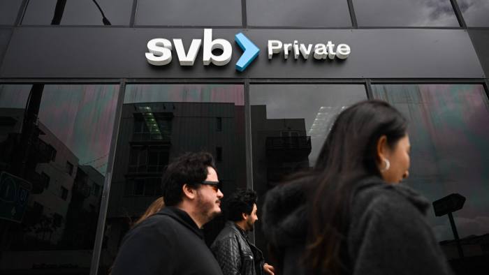 People pass a high street outlet of SVB bank