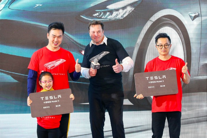 Tesla CEO Elon Musk poses for photos with buyers during the Tesla China-made Model 3 delivery ceremony in Shanghai