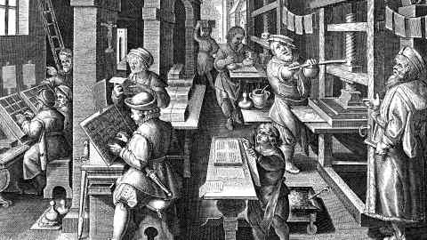 A black and white image of a printing office in Antwerp, circa 1600. On the left compositors are setting up text using letters from a case, while in the centre, type is being inked ready to be printed on to paper in a press on the right. Paper is also being hung to allow ink to dry before being stacked by a boy in the front