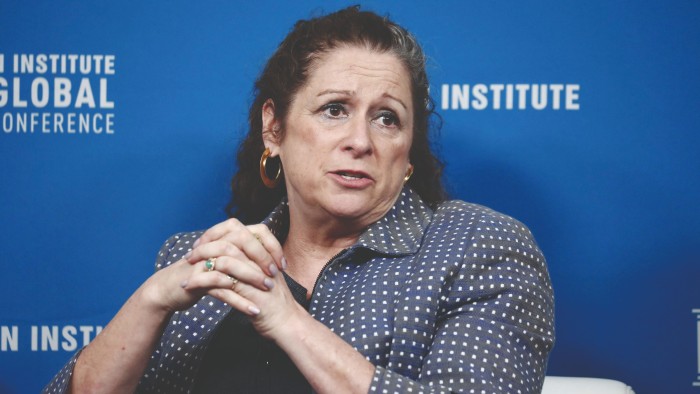Abigail Disney, hands clasped, having a conversation with someone who’s not included in this picture