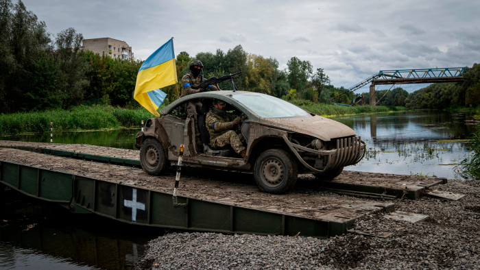 Ukrainian troops drive on a bridge across the Siversky Donets river