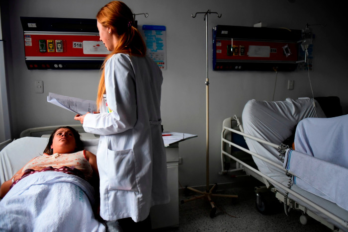 A doctor checks a woman at a hospital in Bogota