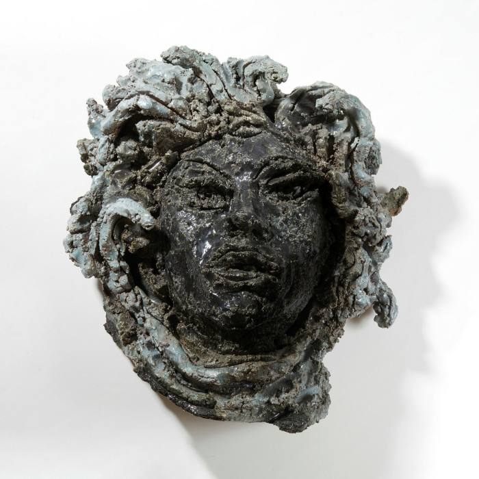 A ceramic mask of a woman with serpentine hair