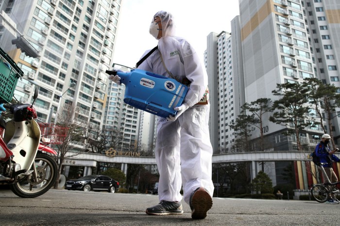 A worker sprays antiseptic solution in Seoul. City officials have executed a series of U-turns and toughened controls since the infection rate began to rise again