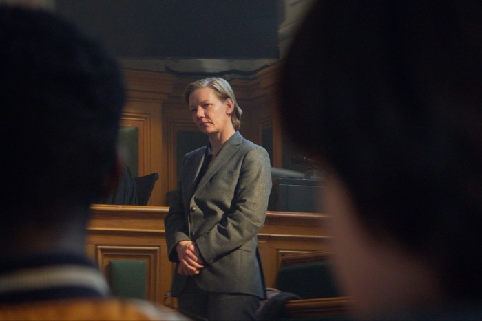 Hüller wears a grey suit and serious expression in a courtroom