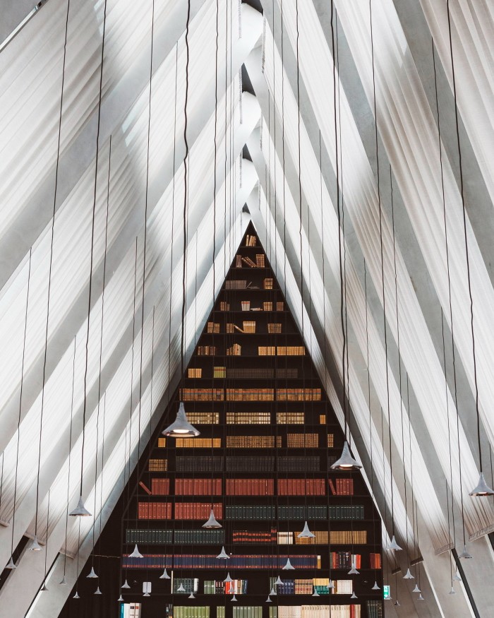 A vast triangular, white-beamed space in the Milan headquarters of publishers Feltrinelli by Herzog & de Meuron, with its triangular far wall lined with books