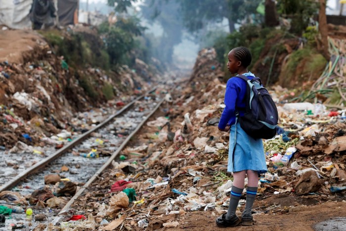 A schoolgirl stands next to the Kenya-Uganda railway line