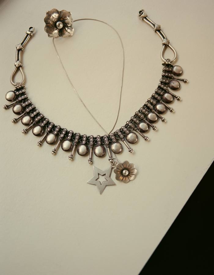 Her style signifier is bold silver jewellery, including a flower on a chain by James Faks and a star that was worn by her SATC character Miranda