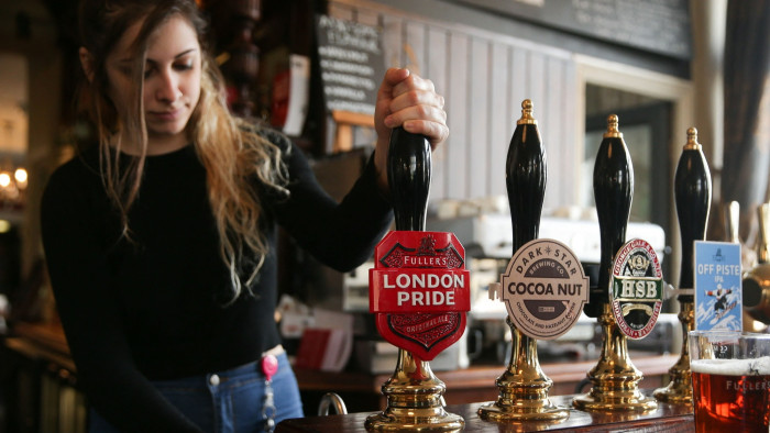 A bartender pulls a pint of Fuller’s London Pride beer