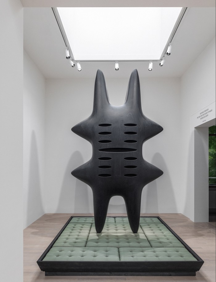 A large black sculpture like a thick hashtag installed in a gallery