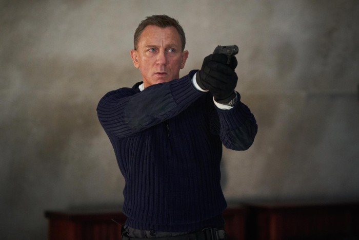 Daniel Craig wears a navy N.Peal army sweater in No Time to Die