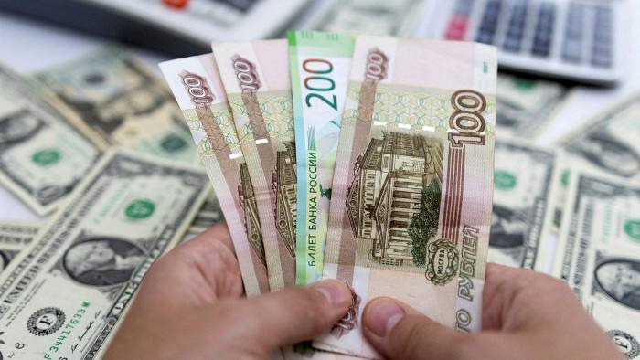 A picture of a woman holding roubles in front of US notes 