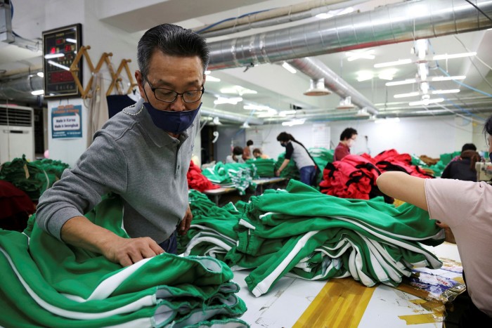 A clothing factory owner checks newly made tracksuits inspired by ‘Squid Game’ at his premises in Seoul