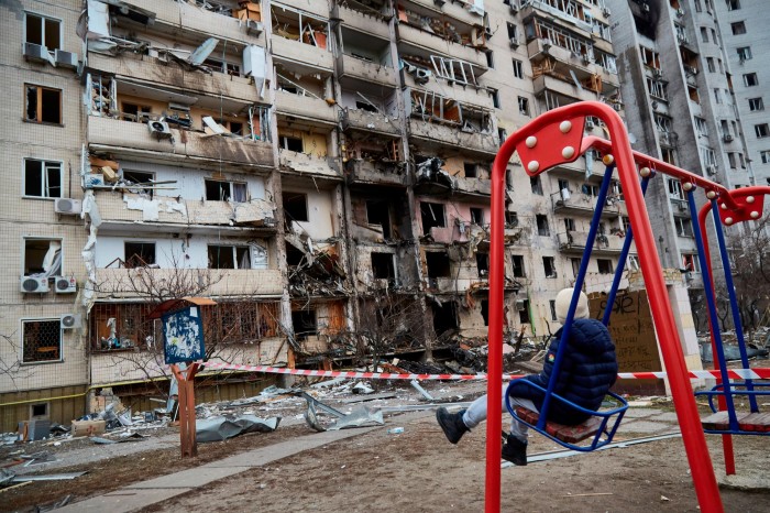 Child outside destroyed building in Kyiv