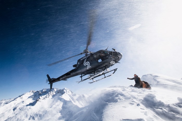 A helicopter lifts off after dropping a group of skiers 
