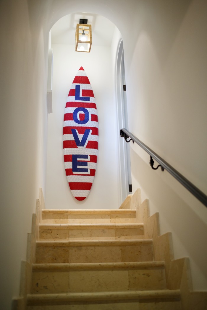 A red and white surfboard with the word Love printed on it