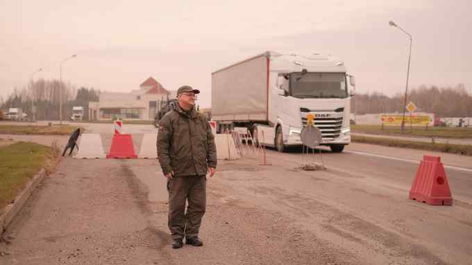 Border guard Saulius Motukas stands at the crossing between Poland and Lithuania