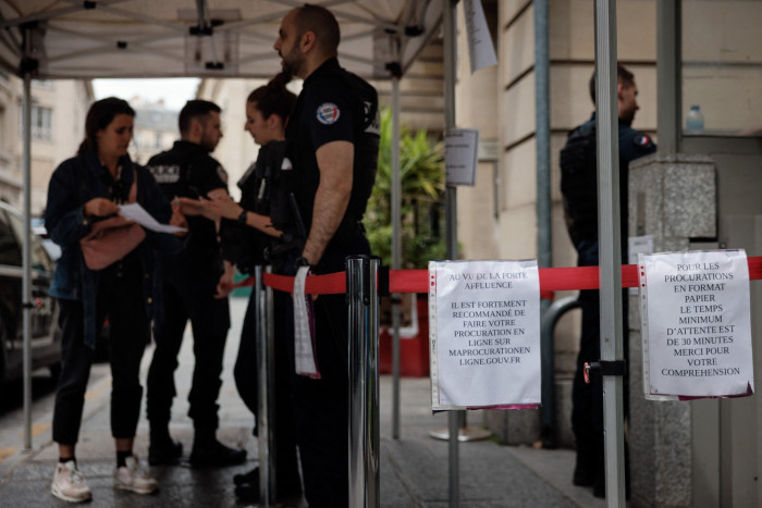 French police officers at the entrance of a police station to obtain a voting proxy