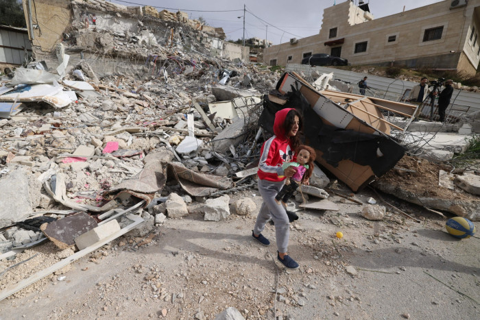 A Palestinian girl picks up her doll from the debris of the house of Rateb Hatab Shukairat, after it was demolished by Israeli bulldozers, in the East Jerusalem neighbourhood of Jabal Mukaber