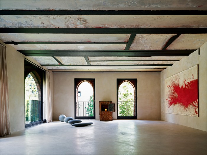 A musican’s loft apartment in Kanaal, Vervoordt’s warehouse complex near Antwerp, featuring a 17th-century French strongbox, Belgian sculptor Dominique Stroobant’s marble pieces La Sfera Schiacciata III, 2007, on the floor and an untitled 1986 painting by Austrian artist Hermann Nitsch
