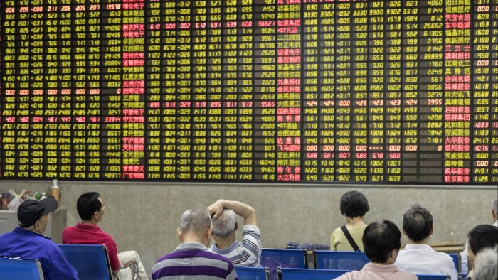 Investors sit in front of an electronic stock board at a securities brokerage in Shanghai, China,