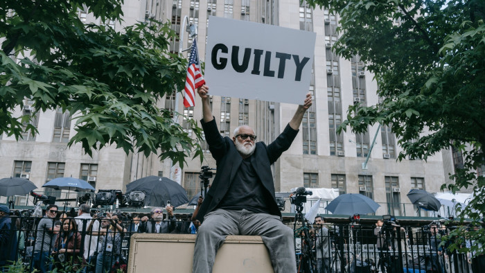 An anti-Trump protester holding up a poster reading ‘Guilty’